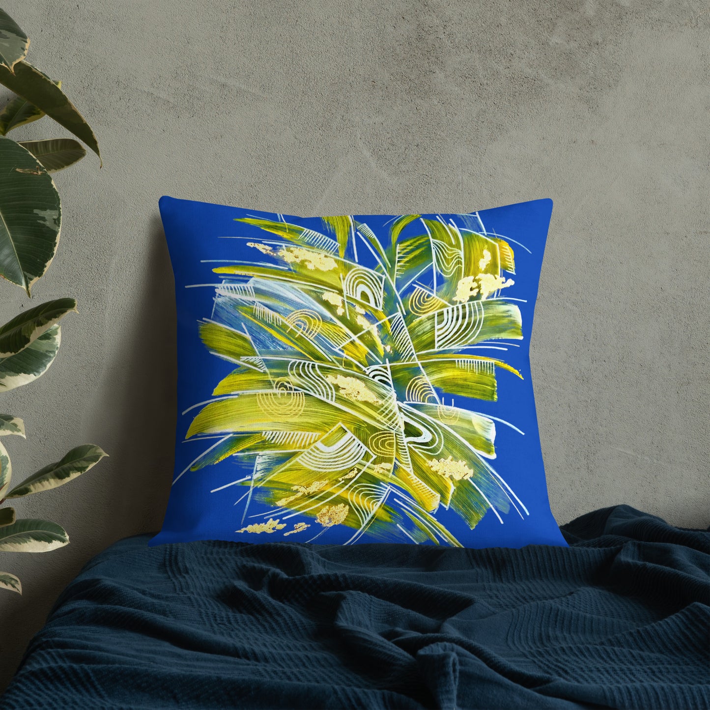 Decorative pillow with abstract leaf design on a blue background, placed on a dark surface. Bright cushions for sofa and contemprorary interior